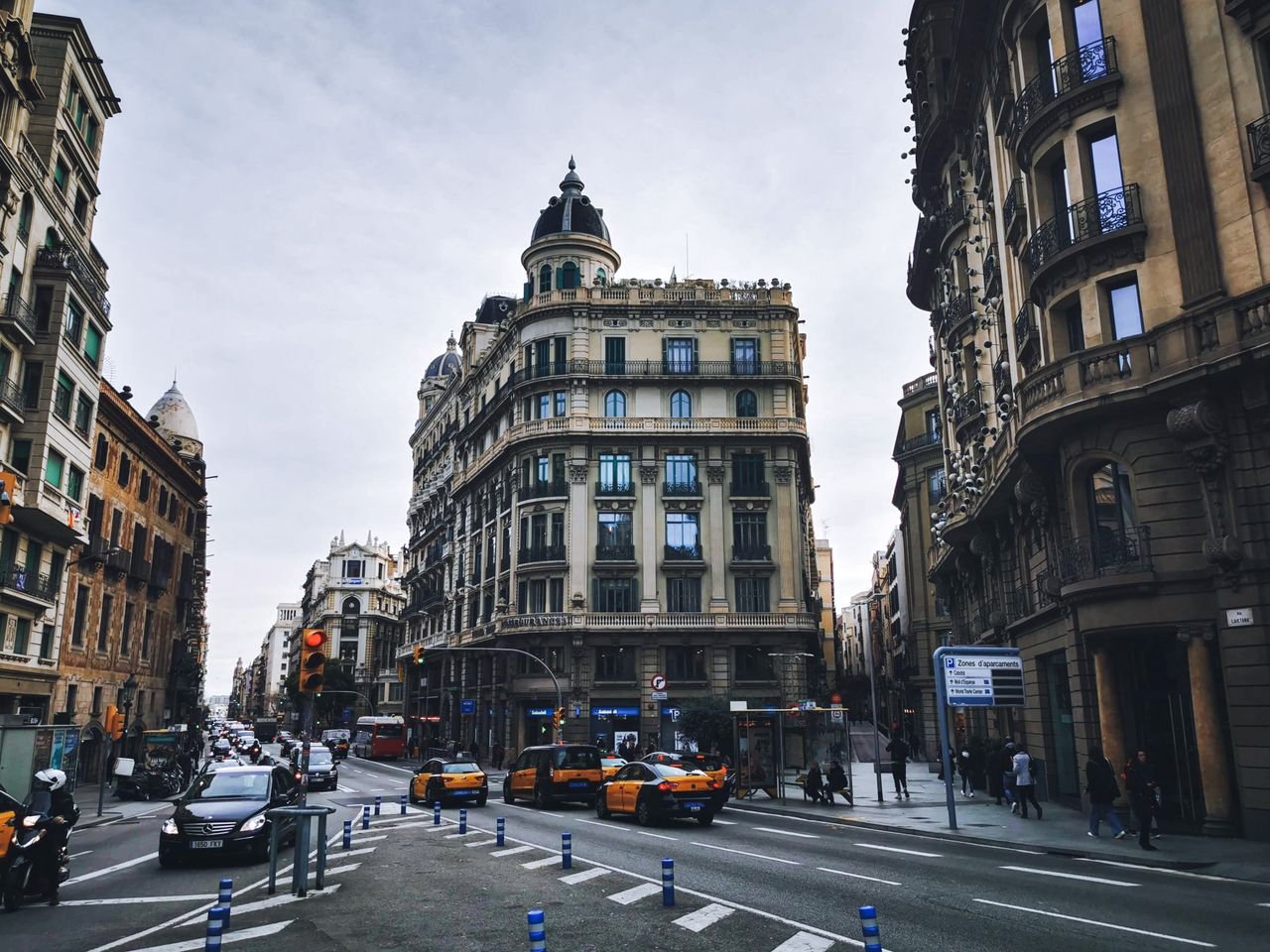 Fully Funded Scholarships in Spain for International Students 2026 and 2027 Historic street view of Barcelona's urban intersection with traditional architecture and traffic.