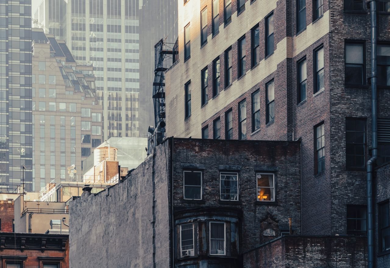 Dramatic view of contrasting architectural styles at dusk in New York City.
